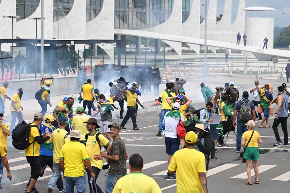 Supporters of Brazilian former President Jair Bolsonaro clash with the police during a demonstration outside the Planalto Palace in Brasilia on January 8, 2023. - Brazilian police used tear gas Sunday to repel hundreds of supporters of far-right ex-president Jair Bolsonaro after they stormed onto Congress grounds one week after President Luis Inacio Lula da Silva's inauguration, an AFP photographer witnessed. (Photo by EVARISTO SA / AFP) (Photo by EVARISTO SA/AFP via Getty Images)