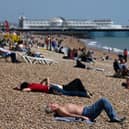 People relax on Brighton in southern England as temperatures rise across the country over the bank holiday weekend (Photo: GLYN KIRK/AFP via Getty Images)