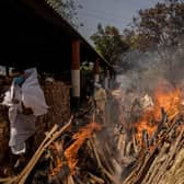 A priest avoids funeral pyres in India, which has been badly hit by a surge in coronavirus cases. (Photo by Anindito Mukherjee/Getty Images)