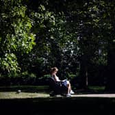 A woman reads a book on a bench in Green Park in central London on September 5, 2023 as the country experiences a late heatwave.