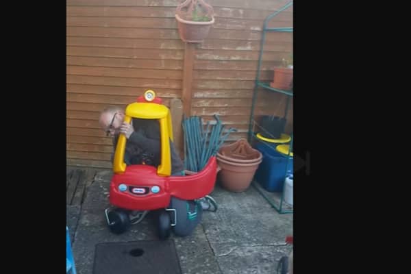 A dad finds it impossible to get out of his toddler's Little Tikes car.