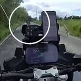 Speeding biker pulls a wheelie.