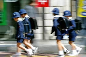 This photo taken 22 April 2004 shows schoolchildren making their way home from class in Tokyo. Photo by YOSHIKAZU TSUNO/AFP via Getty Images