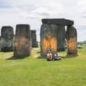 Activists sitting by Stonehenge after it was sprayed orange (Photo: Just Stop Oil / Supplied)