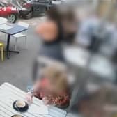 Two cars crash onto pavement narrowly missing café customers.