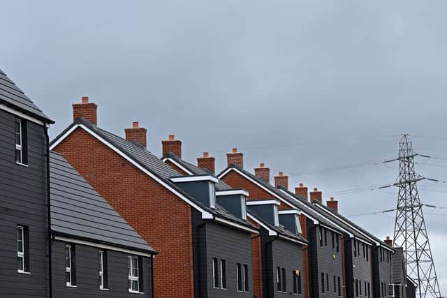 An electricity pylon is pictured beyond newly built residential properties at a construction site for new houses and homes near Aylesbury in July 2023 (Photo: JUSTIN TALLIS/AFP via Getty Images)