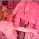 A women looking through her wardrobe full of pink clothes