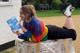 Author Charlotte Faulconbridge reading a book and smiling