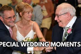 A couple on their wedding day clasping hands with the bride's father