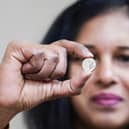 Vasanthi Balachandar, Branch Manager of Jubilee Oak Post Office, displays the first 5p coins bearing the portrait of King Charles III. Around 23.2 million coins have been minted, marking the first 5p design change in 17 years (Photo: Ian West/Royal Mint)