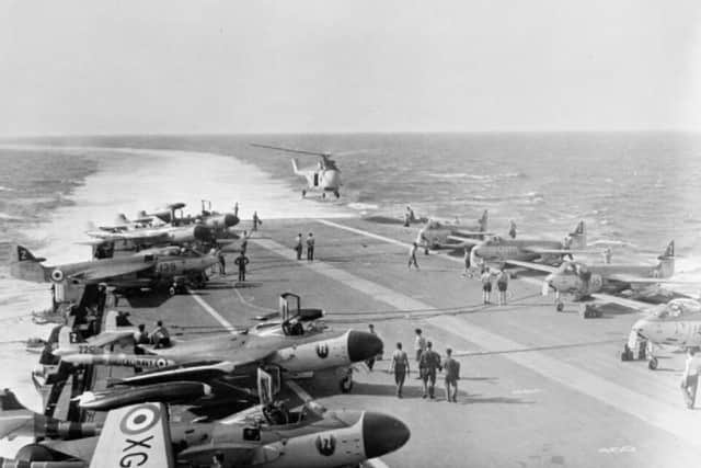 HMS Albion's flight deck with DH Sea Venoms and Hawker Sea Hawks, with a Westland Whirlwind helicopter for emergency rescue operations