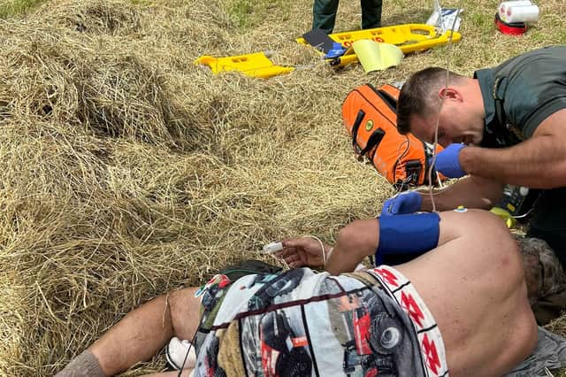 Hertfordshire farmer Will Dickinson being treated by paramedics on farm after the accident.