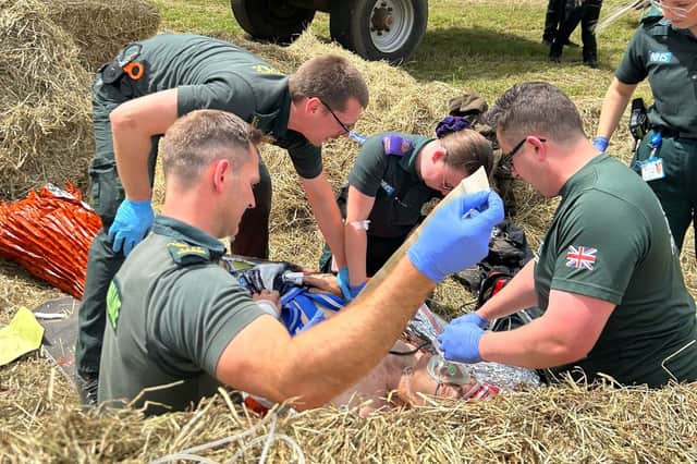 Hertfordshire farmer Will Dickinson being treated by paramedics on farm after the accident.