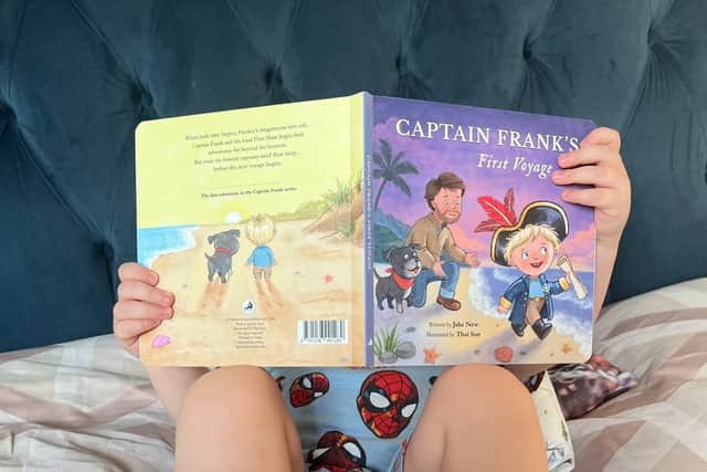 A young reader with Captain Frank’s First Voyage, the new children’s book created by Hemel Hempstead dad Jake New.