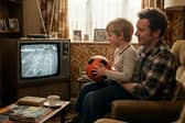 “Vintage living room scene with an adult and child watching a football match on an old television, the child holding a football.”