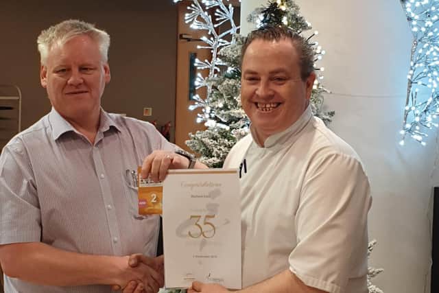 Steve Essam, operations manager for Compass presenting Richard East with his 35 years service certificate