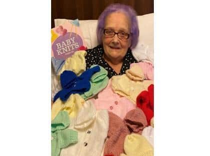 Brenda with some of the baby clothes knitted for the neonatal unit