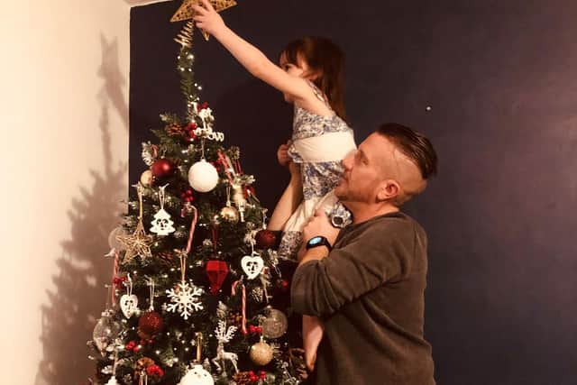 Jenny's partner Nick helps her daughter Edeyn-Rai place the star on their Christmas tree