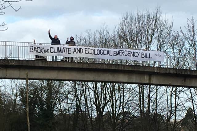 A banner was hung off the A41 bridge by volunteers supporting the Climate and Ecological Emergency Bill