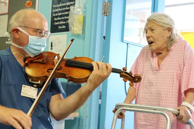 Maxton playing his violin for one of his patients