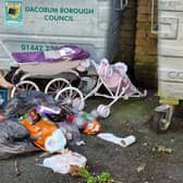 Rubbish dumped between the small block of flats on London Road