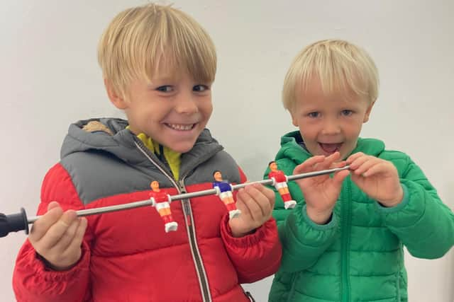 Open Door Repair Cafe's first customers - two very happy little boys with their fixed table football game