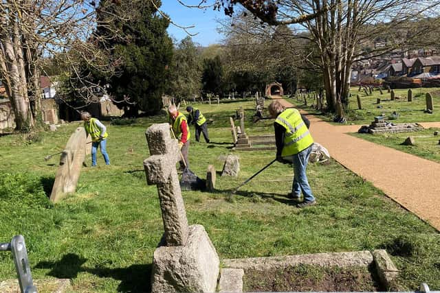Volunteers tend the grounds at Rectory Lane Cemetery