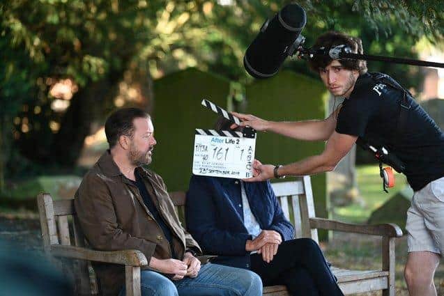 Ricky Gervais getting ready for one of many scenes which takes place on a bench, photo from Netflix
