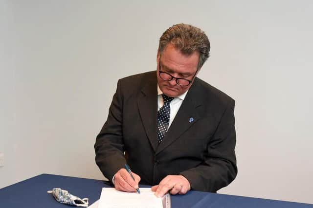 Mr Lloyd signing the oath