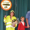 Pictured with lollipop lady Carole Hicks are Paul Allen (far right), who attended the school in 1981 when Carole first started in her role, and his son Elwood (middle) who attends the school