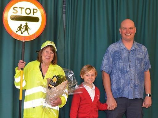 Pictured with lollipop lady Carole Hicks are Paul Allen (far right), who attended the school in 1981 when Carole first started in her role, and his son Elwood (middle) who attends the school