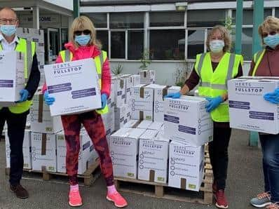 Volunteers, including Leader of Hertfordshire County Council, Richard Roberts, sorting through donations at the temporary donation sorting centre