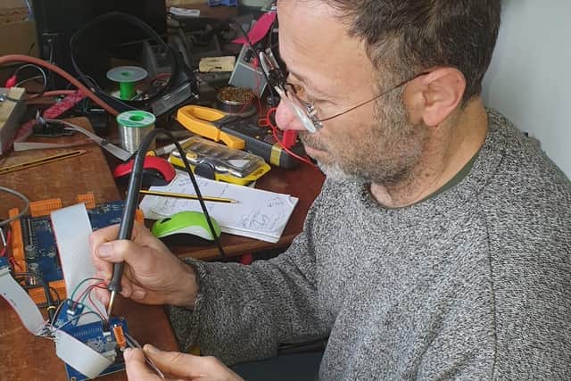 One of the Repair Cafe volunteers repairing by changing a component on a circuit board
