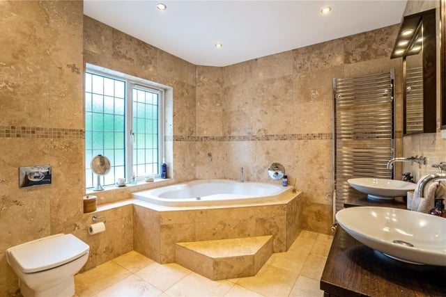 This bathroom has a luxurious Jacuzzi bath and separate shower.