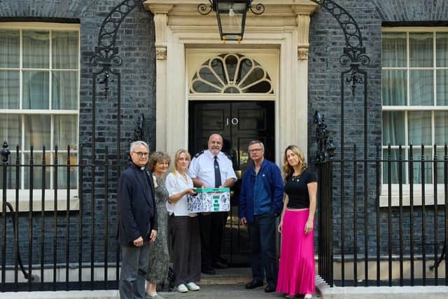 Campaigners pose in front of 10 Downing St.