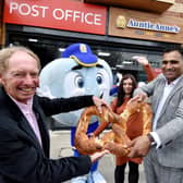 Robert Burton (left), from Auntie Anne's pulls apart a giant pretzel with new owner Saf Abdeen.