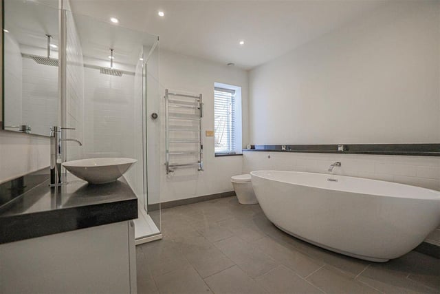 A modern family bathroom includes a generous tub to soak off the working week.