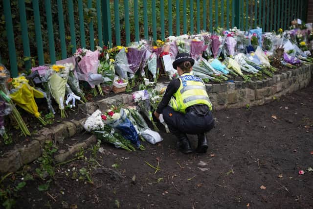 MANCHESTER, ENGLAND - OCTOBER 06: A police officer gathers up floral tributes, that were layed at various points around the police cordon, to a central point outside Heaton Park Hebrew Congregation Synagogue on October 06, 2025 in Manchester, England. On Thursday morning a stabbing and car attack on the Heaton Park Hebrew Congregation Synagogue in the Manchester suburb of Crumpsall left two people dead and four others hospitalized. The attack took place on Yom Kippur, the holiest day of the Jewish calendar, and was declared a terrorist incident by police. The suspected attacker was shot dead by police at the scene. (Photo by Christopher Furlong/Getty Images)