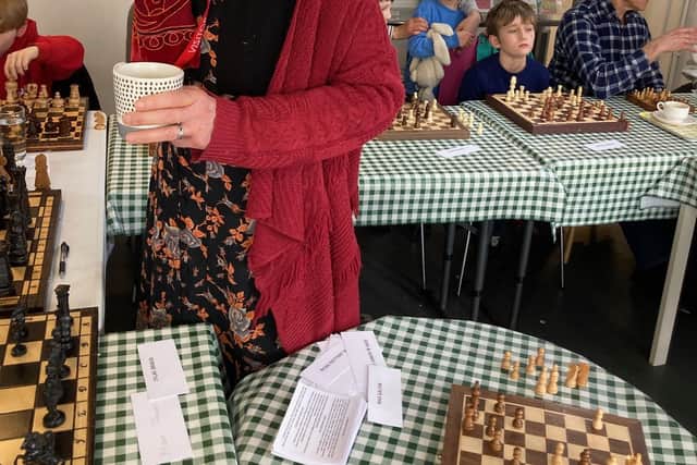 Leslie Tate surrounded by chess players. The former British Under 21 champ took on 15 players at once in an event to raise awareness of climate change