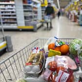 Food items are pictured loaded into a shopping trolley (Photo by DANIEL LEAL/AFP via Getty Images)