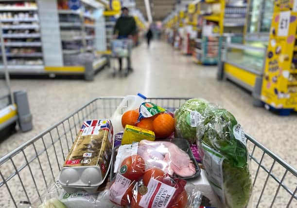 Food items are pictured loaded into a shopping trolley (Photo by DANIEL LEAL/AFP via Getty Images)