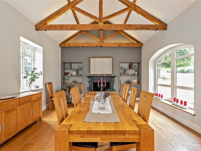 In one wing of the house is an elegant dining room. It was used for a farrier and blacksmith with stalls for horses waiting to be shod, it's been transformed but the exposed ceiling beams are still in place.