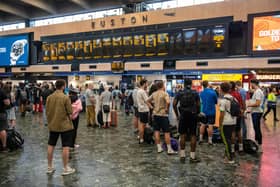 Rail passengers wait for announcements at Euston train station