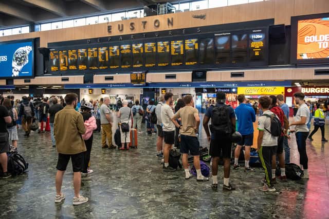 Rail passengers wait for announcements at Euston train station