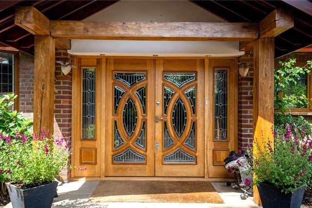 The entrance has ornate oak double doors leading into the house.
