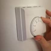 Pictured: Person moving thermostat