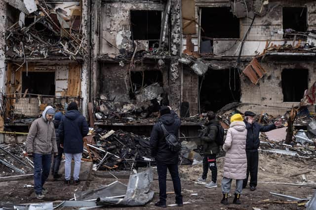 People look at the exterior of a damaged residential block hit by an early morning missile strike on February 25, 2022 in Kyiv, Ukraine.