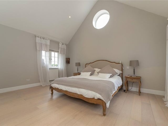 The main bedroom has a vaulted ceiling, dressing room and an en suite with freestanding bath, shower, and a separate toilet.