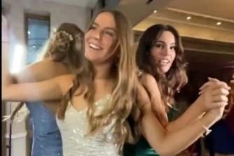 Friends hold hands and dance at their prom.