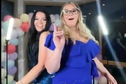 Two friends pose in their blue dresses.